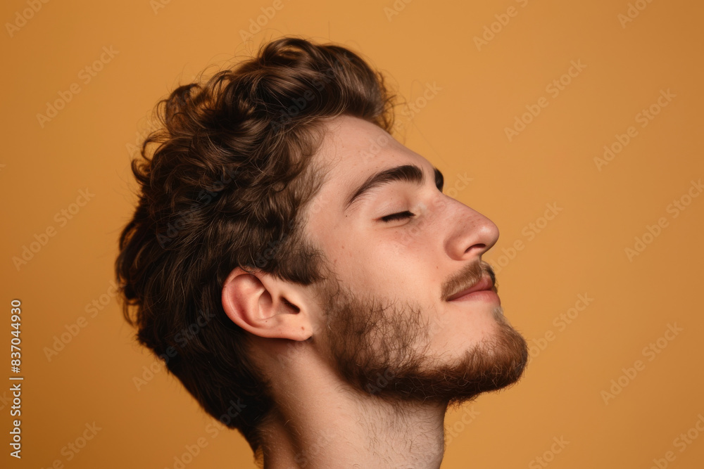 Obraz premium A close up of a man with beard and closed eyes looking to a side