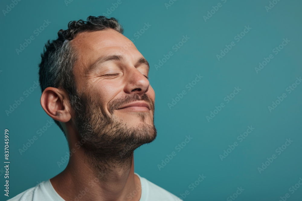 Obraz premium A close up of a man with beard and closed eyes looking to a side