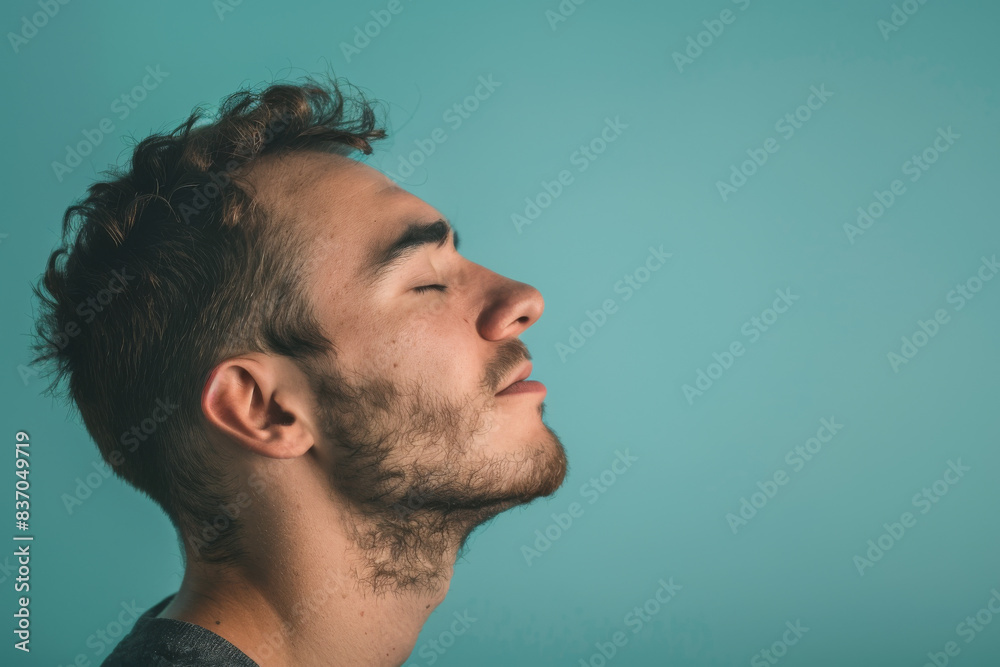Fototapeta premium A close up of a man with beard and closed eyes looking to a side