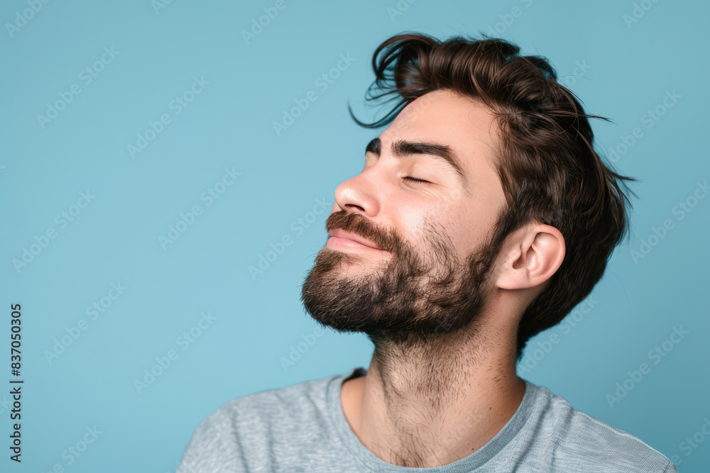 Obraz premium A close up of a man with beard and closed eyes looking to a side