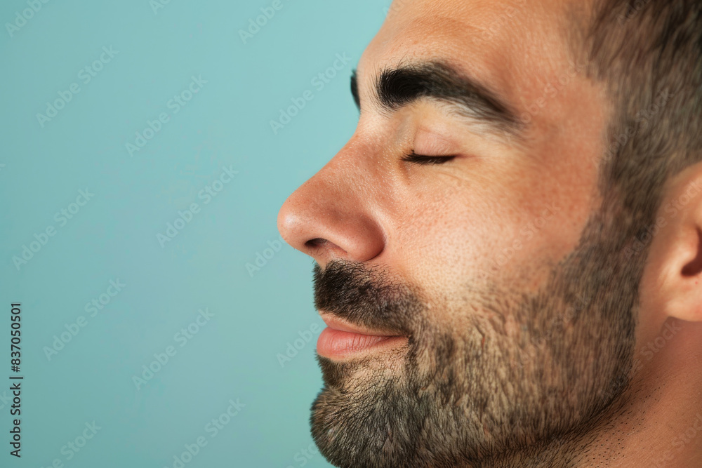 Obraz premium A close up of a man with beard and closed eyes looking to a side