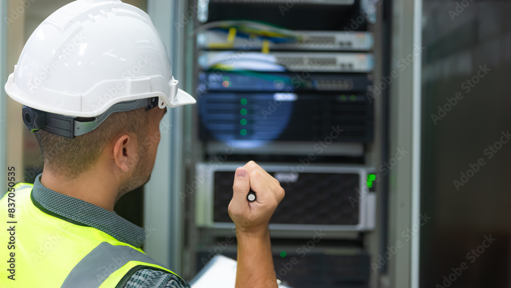 an IT technician working on network Internet cables and servers and try to checklist on the paper an IT technician working on network Internet cables and servers and try to checklist on the paper