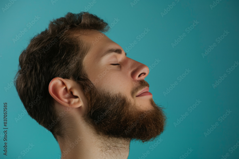 Fototapeta premium A close up of a man with beard and closed eyes looking to a side