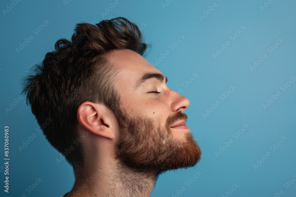 Obraz premium A close up of a man with beard and closed eyes looking to a side