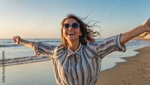 Happy woman with arms outstretched enjoying freedom at the beach - Joyful female having fun walking outside - Healthy lifestyle, happiness and mental health concept