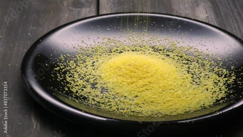 raw polenta falling into black plate, video
