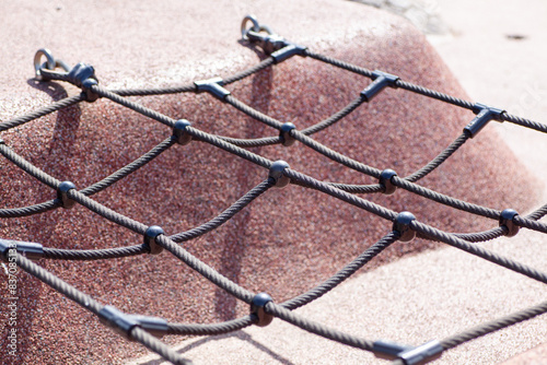 Close-up view of a playground climbing net, showcasing the durable materials and secure fastenings.