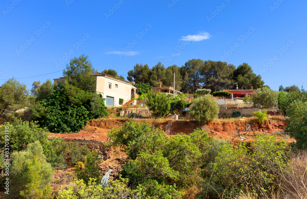 Farmhouse in Spanish village. Village with country houses near orange field. Agricultural field at rural houses in mountains. Rural landscape. Villa near farm field. Rural home on hills in countryside Farmhouse in Spanish village. Village with country houses near orange field. Agricultural field at rural houses in mountains. Rural landscape. Villa near farm field. Rural home on hills in countryside