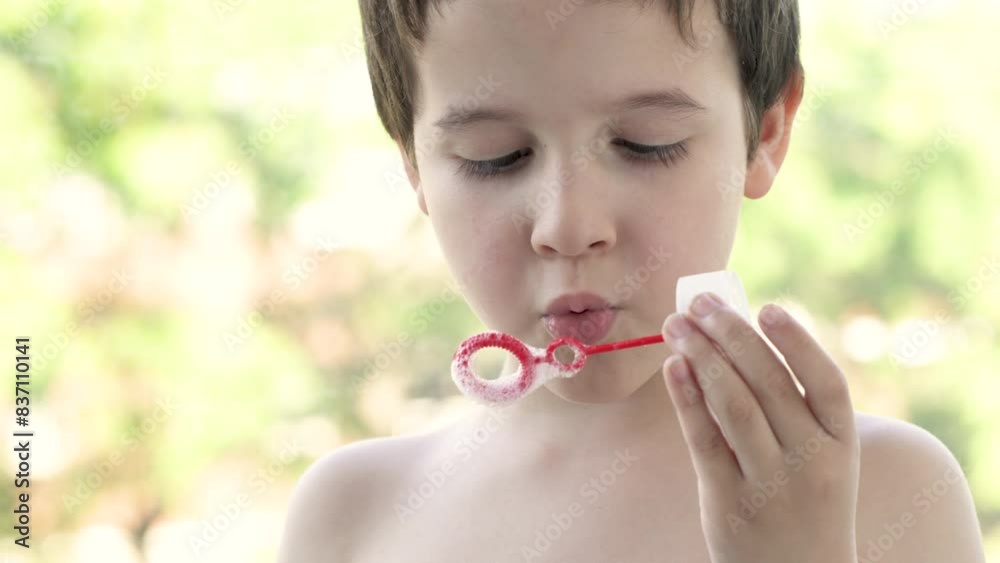Little boy blowing bubbles in field at park Little boy blowing bubbles in field at park