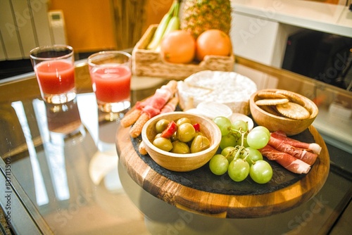 Plateau apéro avec raisin fromage fruits jambon séché sur une table en verre en gros plan
