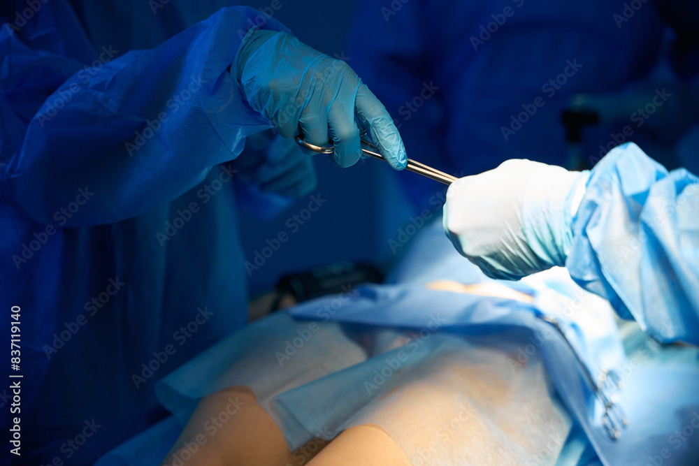 Surgeon equipped with sterile instruments performing operation for patient Surgeon equipped with sterile instruments performing operation for patient