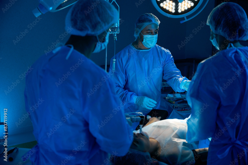 Group of doctors trying to save patient life after injury in operating room Group of doctors trying to save patient life after injury in operating room