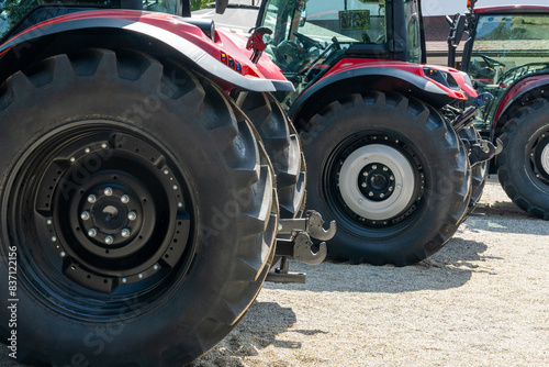 Row of red agricultural tractors for sale.