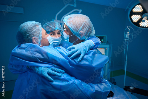 Surgeons staff hugging and rejoicing at well-done surgery