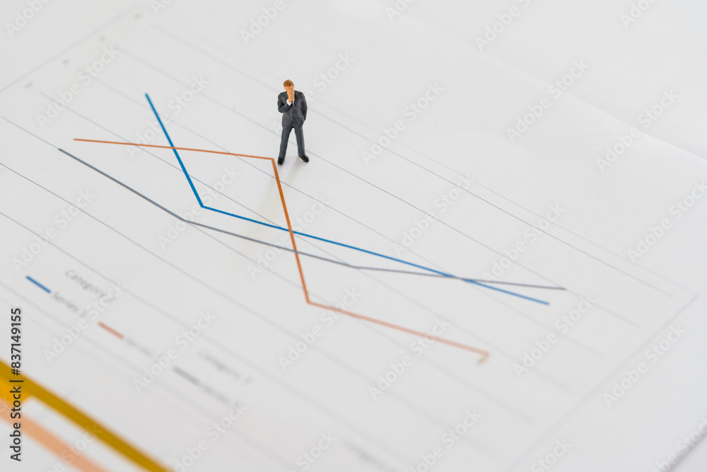 Miniature businessman thinking with the project for presenting investment concept on line graph. Business miniature people on business graph Miniature businessman thinking with the project for presenting investment concept on line graph. Business miniature people on business graph