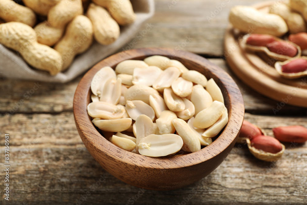 Fresh peanuts in bowl on wooden table, closeup Fresh peanuts in bowl on wooden table, closeup