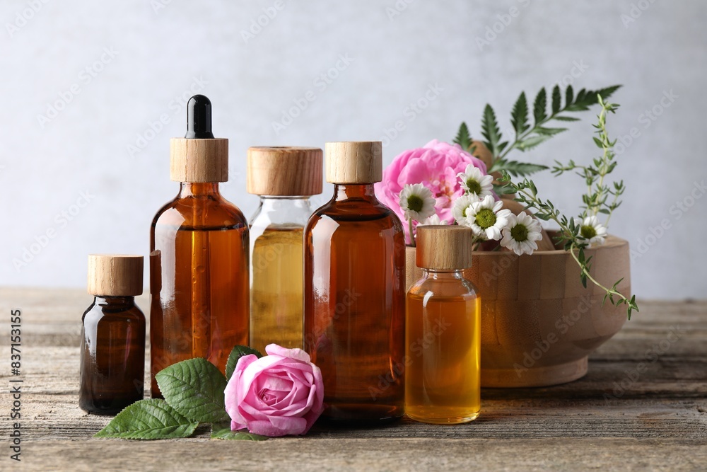 Aromatherapy. Different essential oils and flowers on wooden table Aromatherapy. Different essential oils and flowers on wooden table