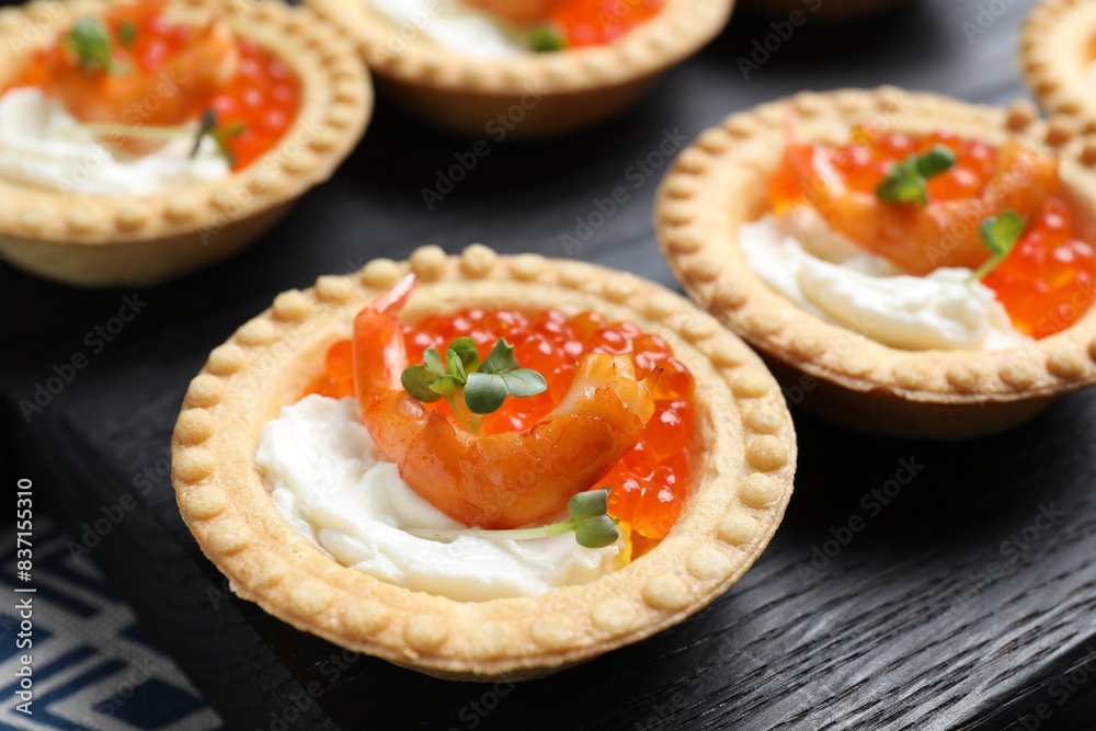 Delicious canapes with shrimps, red caviar and cream cheese on dark table, closeup Delicious canapes with shrimps, red caviar and cream cheese on dark table, closeup