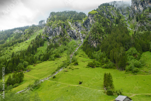 Obraz na płótnie Bergpanorama mit Wasserfall an einem Regentag in den Alpen w salonie