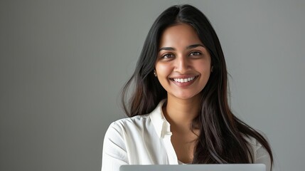 smiling indian woman with laptop positive professional portrait on grey background
