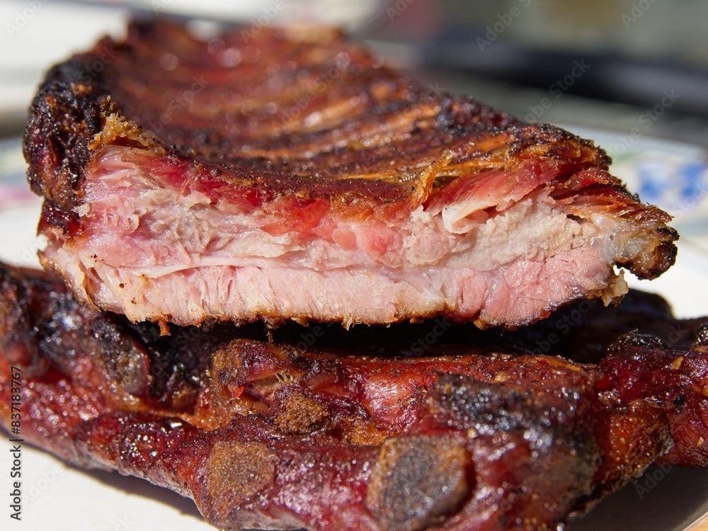 Smoked pork side ribs sliced. Smoke ring and bark visible in a close-up