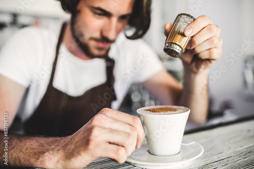 Fotografie Handsome barista working in coffee shop, preparing coffee