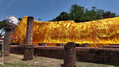 beautiful reclining Buddha at Wat Khun Inthapramun is temple that built in Sukhothai erea. It's exquisite and ancient. The temple is ruin but the Buddha is completely perfect. robe cloth background. photo