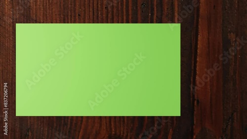 3d Paper (green screen) slideshow on a wooden desk. Can be used for displaying photos, articles. 3d animation. 4K