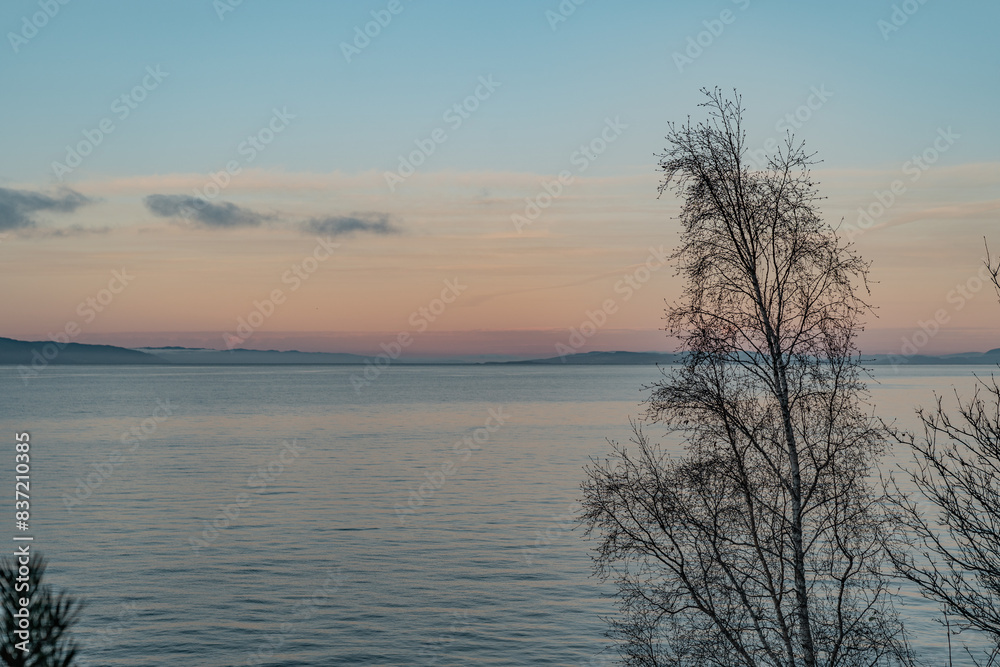 Sunset over the sea with hills and trees. Sunset over the sea with hills and trees.