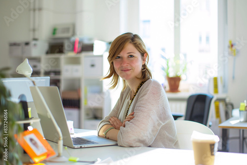 smiling woman sitting at her desk in a bright office space with her laptop and a cup of coffee Free Download smiling woman sitting at her desk in a bright office space with her laptop and a cup of coffee - GFXLoad