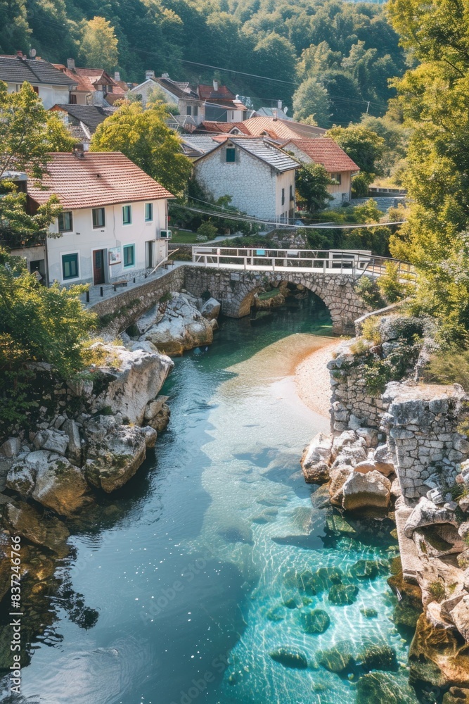 A bridge spans a river adjacent to a small town, suitable for use in images of rural landscapes or urban scenes A bridge spans a river adjacent to a small town, suitable for use in images of rural landscapes or urban scenes