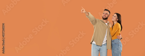 Tablou pe pânză A man and a woman are standing together, both pointing at an unseen object