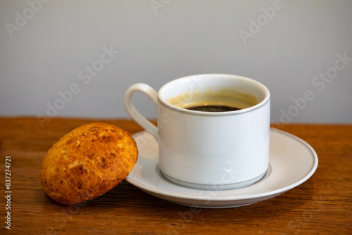 Afternoon coffee served in a white cup with cornbread or cheese bread