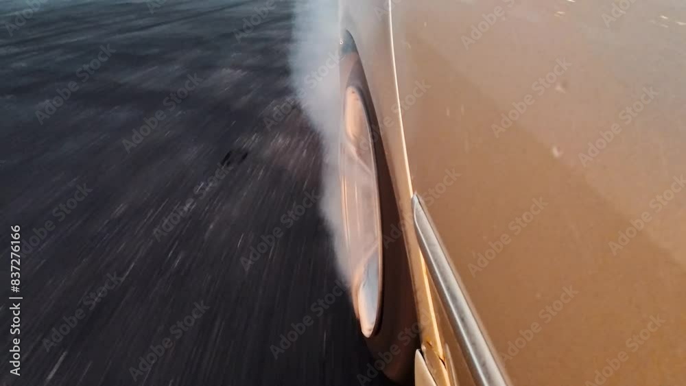 The drift car burns the tires on the rear axle. Close-up shooting. The sunset light.