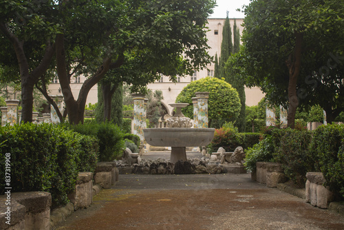 Foto Pathway through a park with fountain and beautiful tiled pillars plated at the cloister garden of Santa Chiara Monastery, Naples, Italy