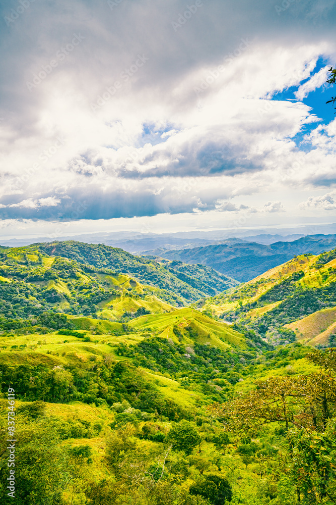 Naklejka premium Verdant slopes of Monteverde under a dynamic sky, showcasing the rich biodiversity and layered mountain vistas of Puntarenas Province, Costa Rica. High quality photo.