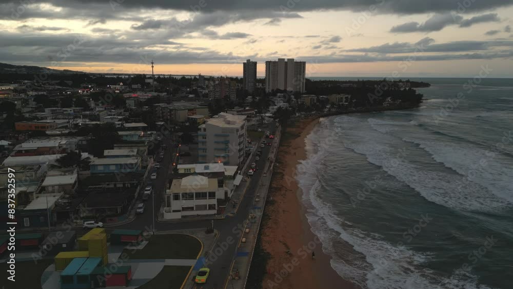 aerial view of luquillo puerto rico skyline with waves crashing on the beach (tropical caribbean island town at sunset, dusk) night time tall hotel apartment buildings sand sea ocean paradise aerial view of luquillo puerto rico skyline with waves crashing on the beach (tropical caribbean island town at sunset, dusk) night time tall hotel apartment buildings sand sea ocean paradise