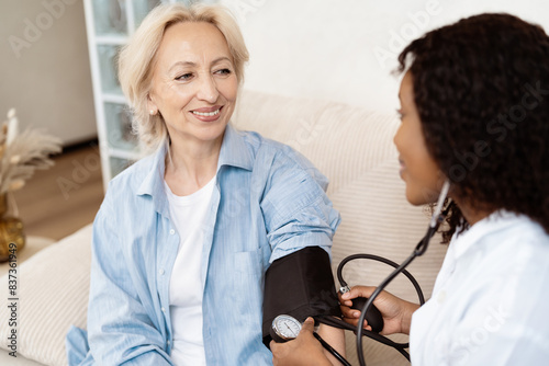 Photos Senior Woman Receiving Blood Pressure Check From Doctor At Home, Showcasing Healthcare, Wellness, And Medical Support