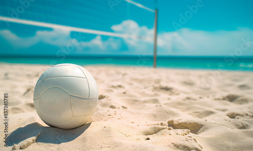 Sandy beach volleyball court with ball, net,and clear blue sky. Ideal for travel agency marketing, vacation planning websites, and sports event announcements, includes spacious copy space for messages photo