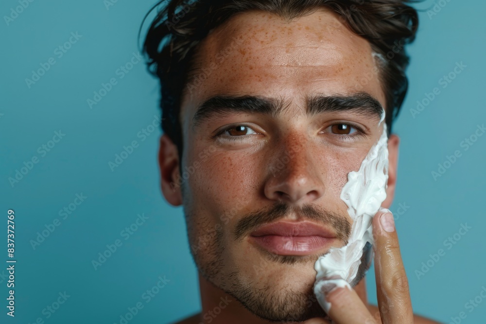 Fotografie Man shaving his face with a razor blade