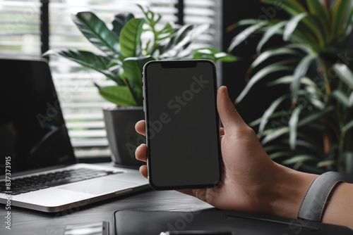 Person holding phone while sitting at desk