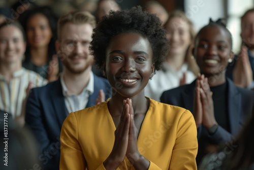 Woman in yellow shirt clapping in front of crowd