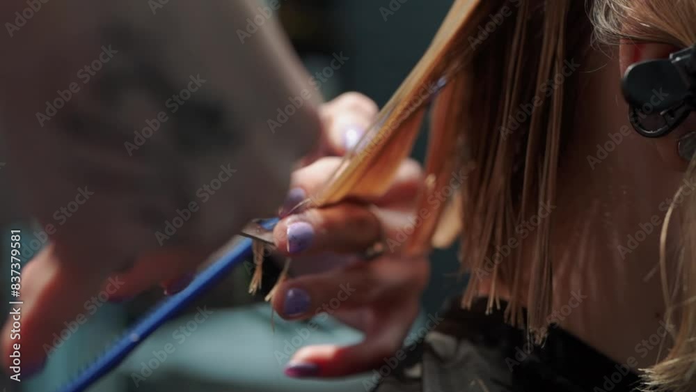 a beautiful young girl with short hair and a bob haircut is doing a procedure in a beauty salon. Hair master doing coloring and tone to client's hair close-up