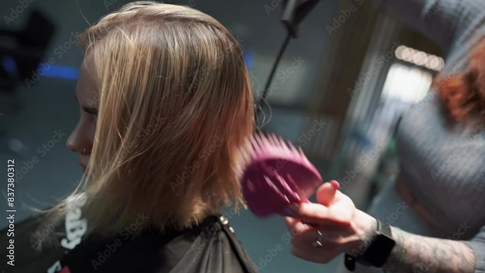 a beautiful young girl with short hair and a bob haircut is doing a procedure in a beauty salon. Hair master doing coloring and tone to client's hair close-up a beautiful young girl with short hair and a bob haircut is doing a procedure in a beauty salon. Hair master doing coloring and tone to client's hair close-up