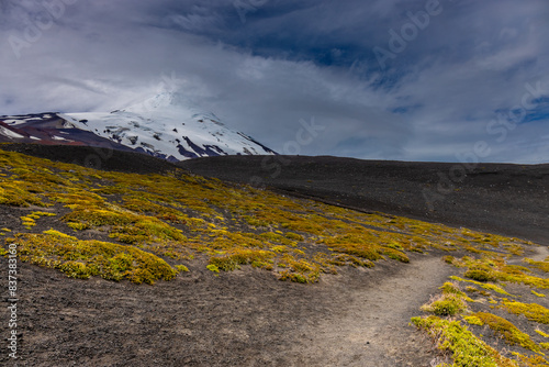 Osorno volcano mountain summit in Chile, Patagonia Andes. The ring of fire volcanic landscape with crater and lava active volcano in South America. Red rock frozen lava and snow on volcano top photo