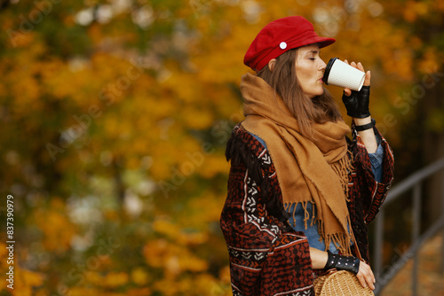 stylish female in red hat with scarf  gloves  bag and coffee