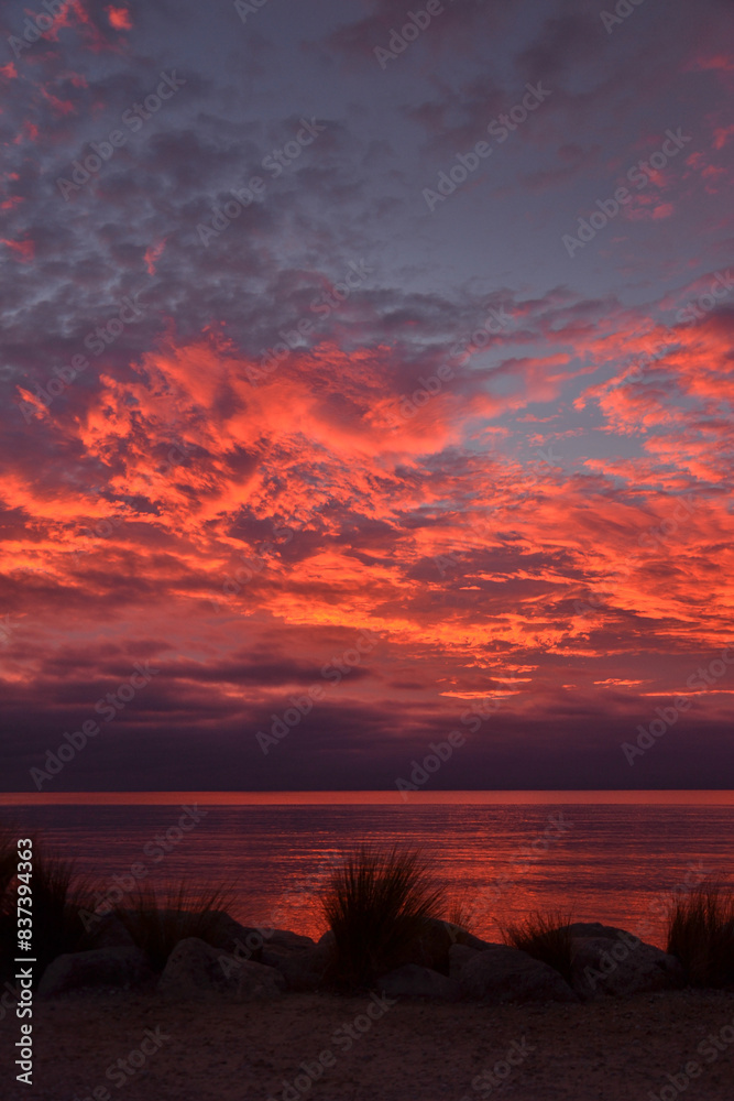 Fototapeta premium Dramatic glowing sunrise at a beach in Marahau, New Zealand