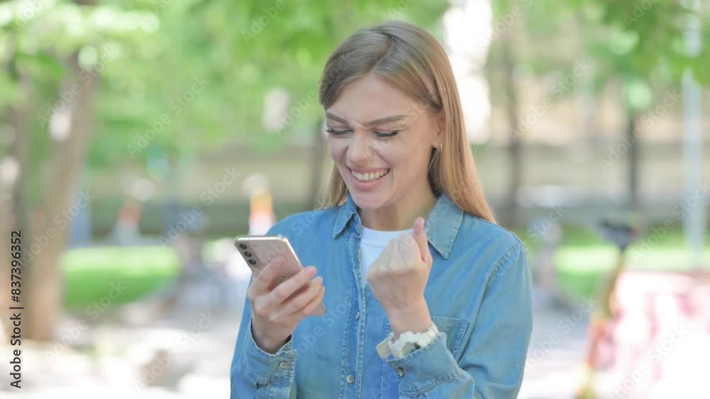 Woman Celebrating Successful Trade on Phone Outdoor in Park Woman Celebrating Successful Trade on Phone Outdoor in Park