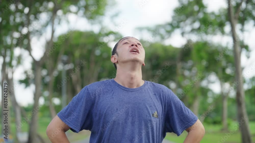 Asian man using smart watch checking heart rate and calories burned during jogging exercise at park. Healthy man do sport training fitness workout running in the city. Health care technology concept. Asian man using smart watch checking heart rate and calories burned during jogging exercise at park. Healthy man do sport training fitness workout running in the city. Health care technology concept.