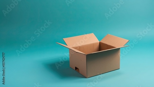 Empty open cardboard box on turquoise background, ideal for shipping or storage concept